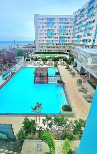 an overhead view of a large swimming pool in a hotel at A Marina Spatial 2BR , 2Showers, 1Balcony, 1 Storage Room in Dumaguete
