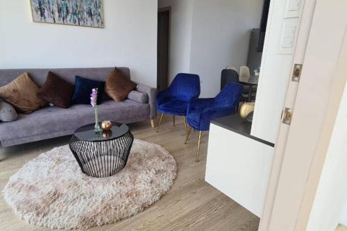 a living room with a couch and blue chairs at Departamento con vista al mar in Jaramijó