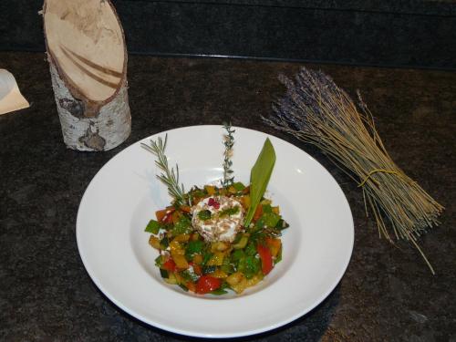 a white plate with a salad on a table at Hotel Natur-Landhaus Krone in Maierhöfen