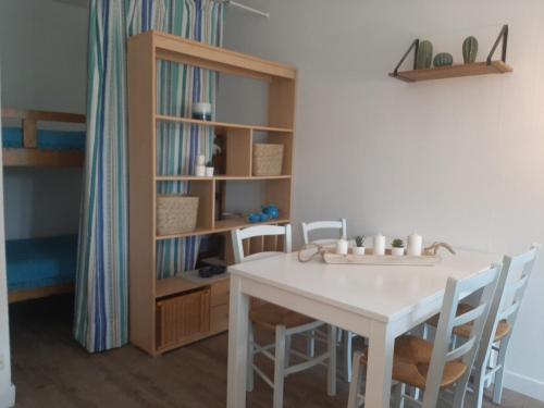 une pièce avec une table, des chaises et une étagère dans l'établissement À deux pas des commerces et de l'océan, appartement rénové avec terrasse à Seignosse - FR-1-239-413, à Seignosse