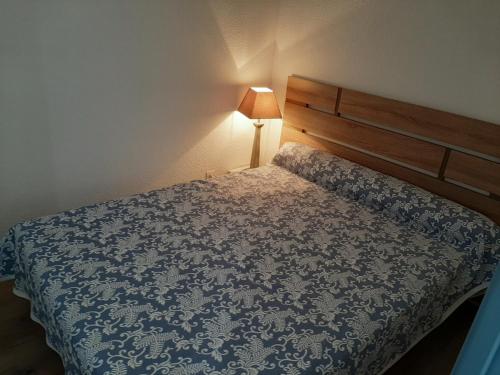 une chambre avec un lit avec une couette bleue dans l'établissement À deux pas des commerces et de l'océan, appartement rénové avec terrasse à Seignosse - FR-1-239-413, à Seignosse