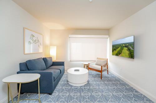 a living room with a blue couch and a chair at The Inn at LBI National Golf & Resort in Little Egg Harbor Township