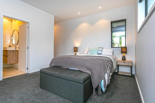 a bedroom with a large bed and a mirror at Hahei Heights in Hahei