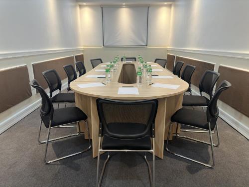 a conference room with a wooden table and chairs at MetroCentre Hotel in Tagbilaran City