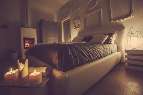 a bedroom with a bed and two candles on a table at Langhe Country House in Neive