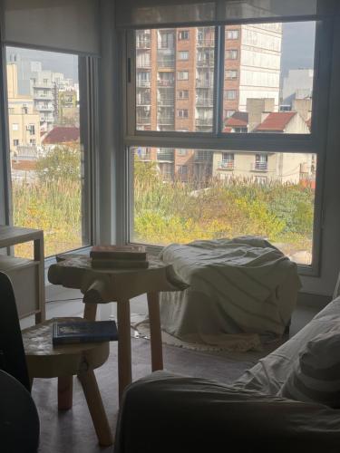 a bedroom with a bed and a large window at Lovely sunset department in Morón