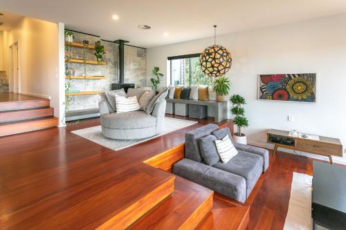 a living room with two chairs and a couch at Hahei Heights in Hahei