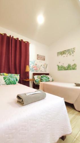 two beds in a room with red curtains at Olango Transient Home,with WIFI &Netfix in Santa Rosa