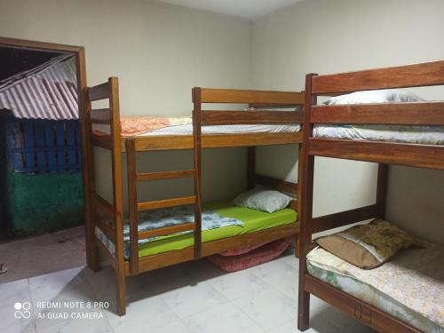 Habitación con 3 literas y espejo. en Camping & hostel tô á toa jeri, en Jericoacoara