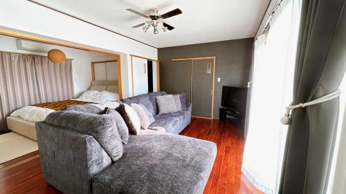 a living room with a couch and a bed at Ocean View Terrace BISE 1F in Motobu