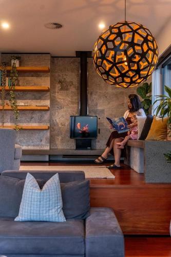 two women sitting on a couch in a living room at Hahei Heights in Hahei