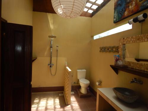 a bathroom with a shower and a toilet and a sink at Alamanda Family Villas, Pool & Local Tours in Yogyakarta
