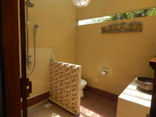 a bathroom with a toilet and a sink at Alamanda Family Villas, Pool & Local Tours in Yogyakarta