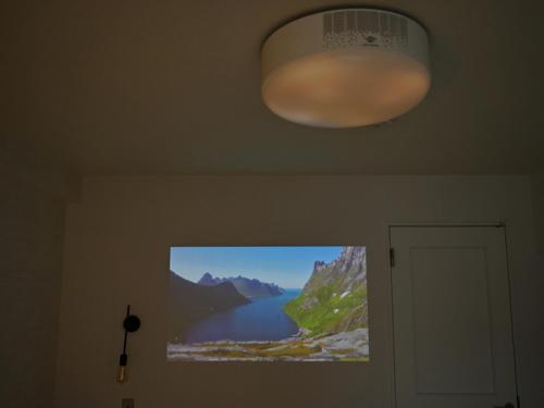 a television hanging on a wall with a picture of a lake at シャトーひらぎし in Sapporo