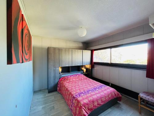 ein Schlafzimmer mit einem Bett und einem großen Fenster in der Unterkunft Appartement au Mont-Dore - 2 pièces, 34m², loggia et parking, proche centre et Thermes - FR-1-608-257 in Mont-Dore