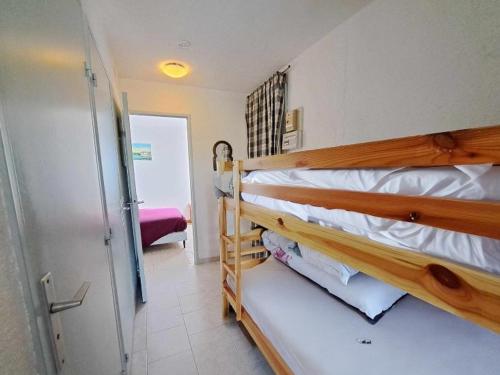 Ce dortoir comprend 2 lits superposés et une porte. dans l'établissement Appartement 2 pièces accès direct plage avec parking privé - FR-1-326-823, à Marseillan
