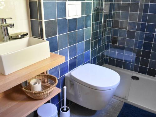 La salle de bains est pourvue de carrelage bleu, de toilettes et d'un lavabo. dans l'établissement Chalet 5 pièces pour 12 pers. avec cheminée et animaux acceptés - FR-1-180-616, à Les Allues