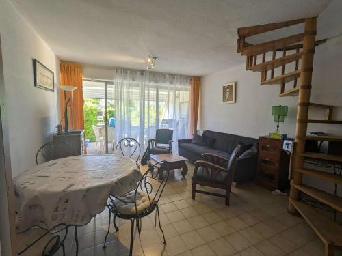 un salon avec une table et un canapé dans l'établissement Duplex en bord de mer avec jardin privé et accès direct à la plage, climatisation, parking et internet. - FR-1-250-282, à La Grande Motte