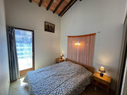 une chambre avec un lit et une grande fenêtre dans l'établissement Pavillon T3 avec Mezzanine, Garage, Clim, Terrasse, Piscine, 400m Plage - Saint Cyprien - FR-1-106-103, à Saint-Cyprien