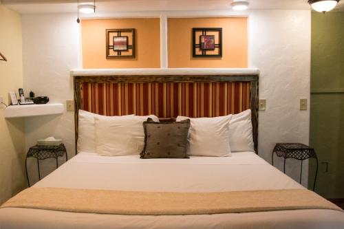 a bedroom with a large bed with white pillows at Chalet Kilauea in Volcano