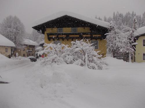 a house covered in snow in front at Pension Haus Rohrmoser in Annaberg im Lammertal
