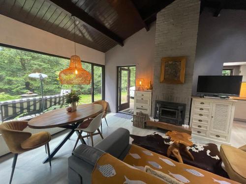 a living room with a table and a fireplace at Magical Cottage in the woods in Baarn