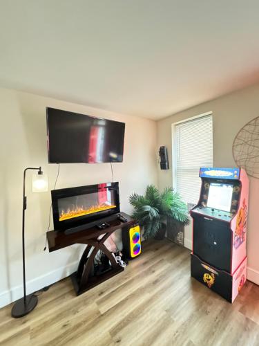 a living room with a tv and a video game at Downtown Loft - Close to Topgolf, Horseshoe Casino, UM Baltimore in Baltimore