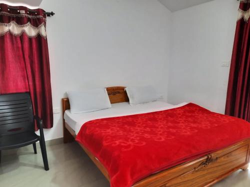 a bedroom with a bed with a red blanket at Neo Nirmal Residency in Ooty