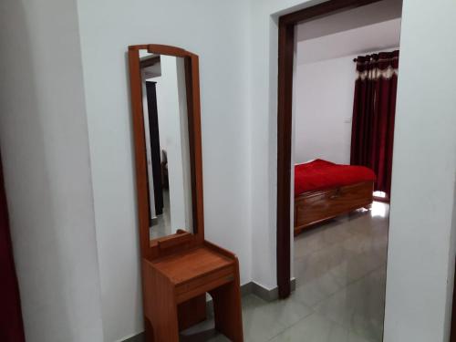 a mirror and a wooden dresser in a room at Neo Nirmal Residency in Ooty