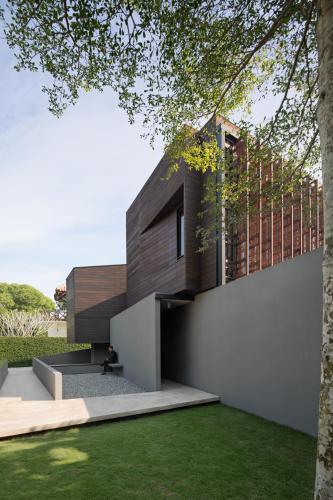 a person sits on a bench in front of a house at Awrawikara by REJA Reserve in Bogor