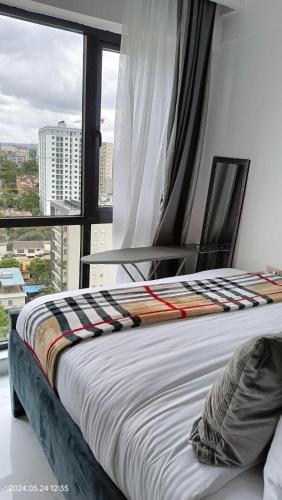 a bed in a room with a large window at SmartHomes A1406 SmartHomes in Nairobi