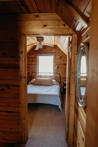 a bedroom with a bed in a log cabin at Beautiful Alaskan Log Cabin on Wooded Lot in Wasilla