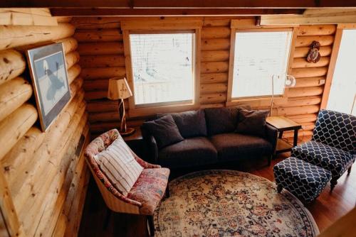 a living room with a couch and chairs in a log cabin at Beautiful Alaskan Log Cabin on Wooded Lot in Wasilla