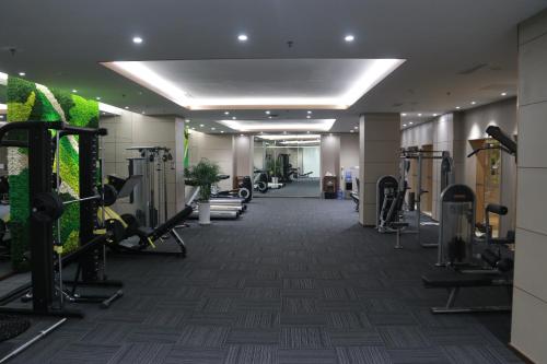 a gym with cardio equipment in a hotel lobby at Wyndham Qingdao l Free Fixed-Time Shuttle Service Between Hotel and Airport & North Railway Station l Outdoor Children's Amusement Park l 1-Hour Play Snooker or Table Tennis in Qingdao