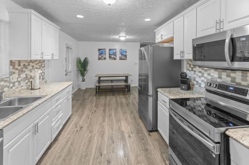 a kitchen with white cabinets and stainless steel appliances at 5BD 2BTH Home Near Hartsfield Jackson Airport in College Park