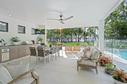 a kitchen and dining room with a table and chairs at Belle Escapes Beach Manor in Palm Cove