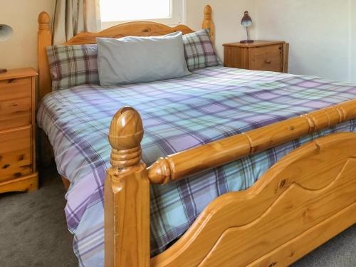 a bedroom with a wooden bed with a wooden frame at Cow Boy Cabin - Uk47145 in Glasgow