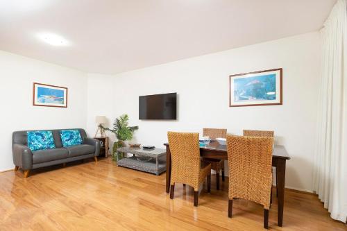Un comedor con una mesa y un sofá. en Sunrise 202, en Tuncurry