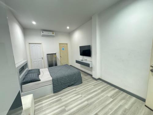 - une chambre avec un lit et une télévision à écran plat dans l'établissement K&K Apartment, à Bang Phli