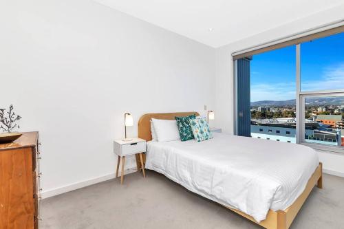 a bedroom with a bed and a large window at 'The Hindmarsh' Hotel-style Pad with Hills Panorama in Adelaide