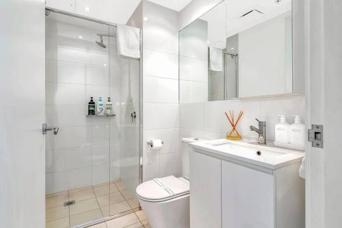 a bathroom with a shower and a toilet and a sink at 'The Hindmarsh' Hotel-style Pad with Hills Panorama in Adelaide