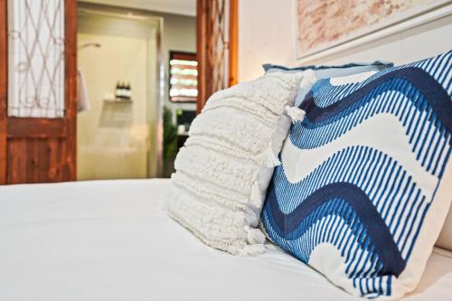 a blue and white pillow sitting on top of a bed at Sudbury Shores Beach House in Kewarra Beach