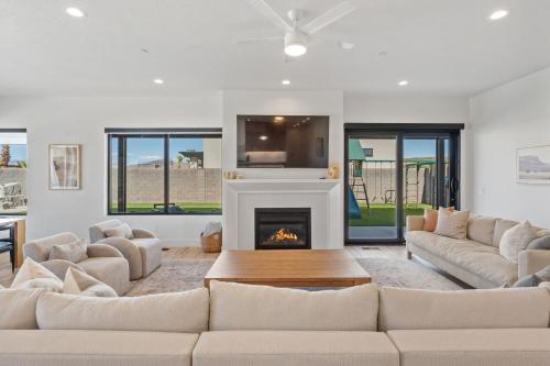 a living room with a couch and a fireplace at Pecan Valley Oasis - Lux Pool, Sauna and Theater in Hurricane