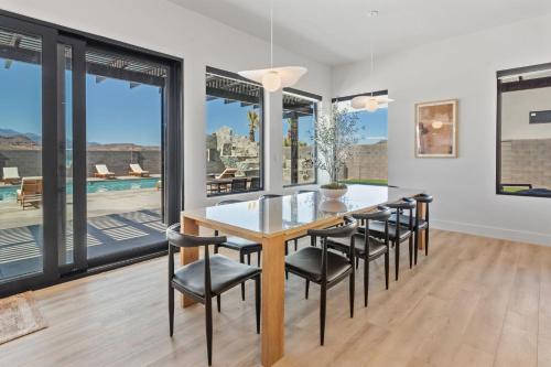 a dining room with a table and chairs and large windows at Pecan Valley Oasis - Lux Pool, Sauna and Theater in Hurricane