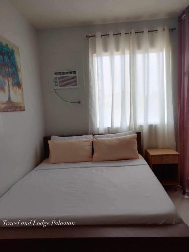 a bed in a room with a large window at Travel and Lodge Palawan in Puerto Princesa City