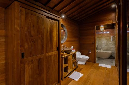 a bathroom with a toilet and a sink and a tub at Ithaca Ubud Villa in Ubud