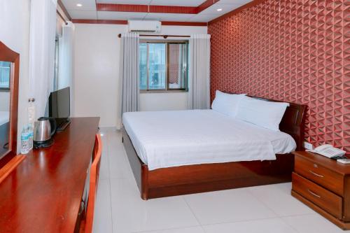 a bedroom with a bed and a desk and a television at Phúc Đạt Hotel in Vung Tau