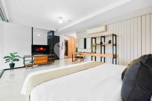 a bedroom with a white bed and a fireplace at Sovrae by Kozystay - Grogol in Jakarta