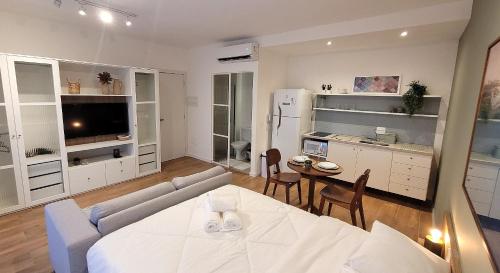 a living room with a couch and a table with chairs at Blend Coliving One - 2b in Ribeirão Preto