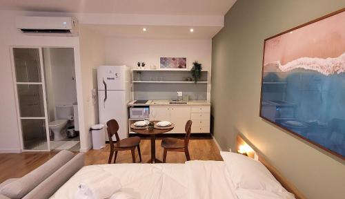 a bedroom with a bed and a table and chairs at Blend Coliving One - 2b in Ribeirão Preto